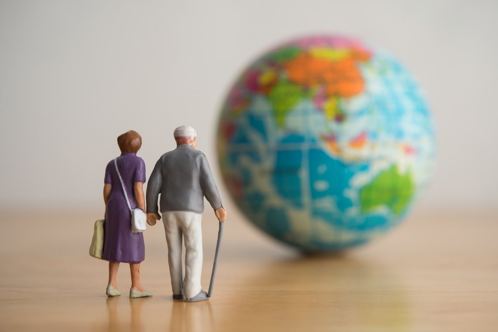 An older couple looking at a large globe